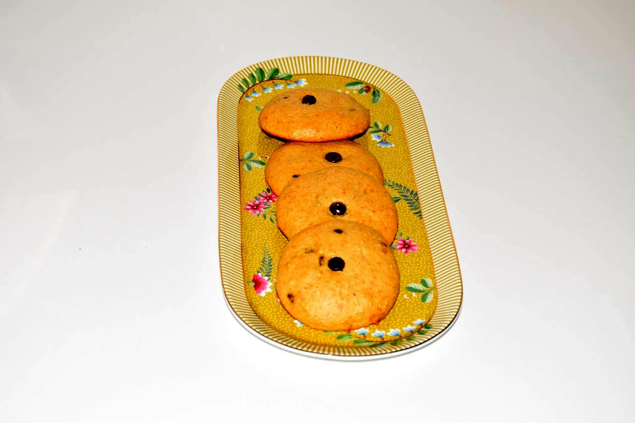 Three oat cookies arranged on a yellow floral serving plate